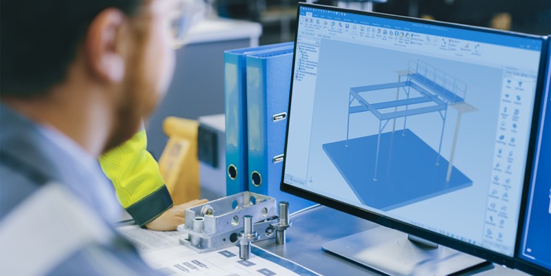 Engineer designing a 3D CAD model of a metal structure on a computer screen