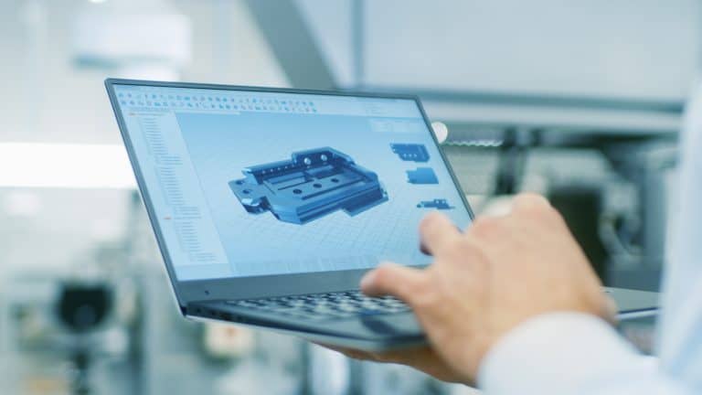 Ingenieur gebruikt een laptop met CAD-software om een 3D-model van een technisch onderdeel te bekijken en te bewerken.