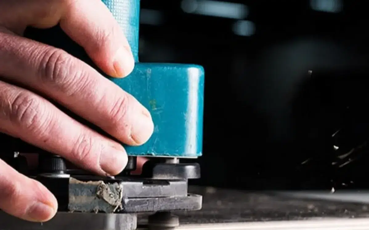 Medewerker van Idos Interieurs aan het werk met een machine om materialen klaar te maken.