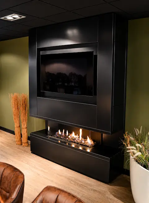 Elegante, moderne Kinowand mit schwarzem Finish, eingebautem Fernseher und stimmungsvollem Gaskamin in einem luxuriösen Interieur mit Holzboden und Zierpflanzen.