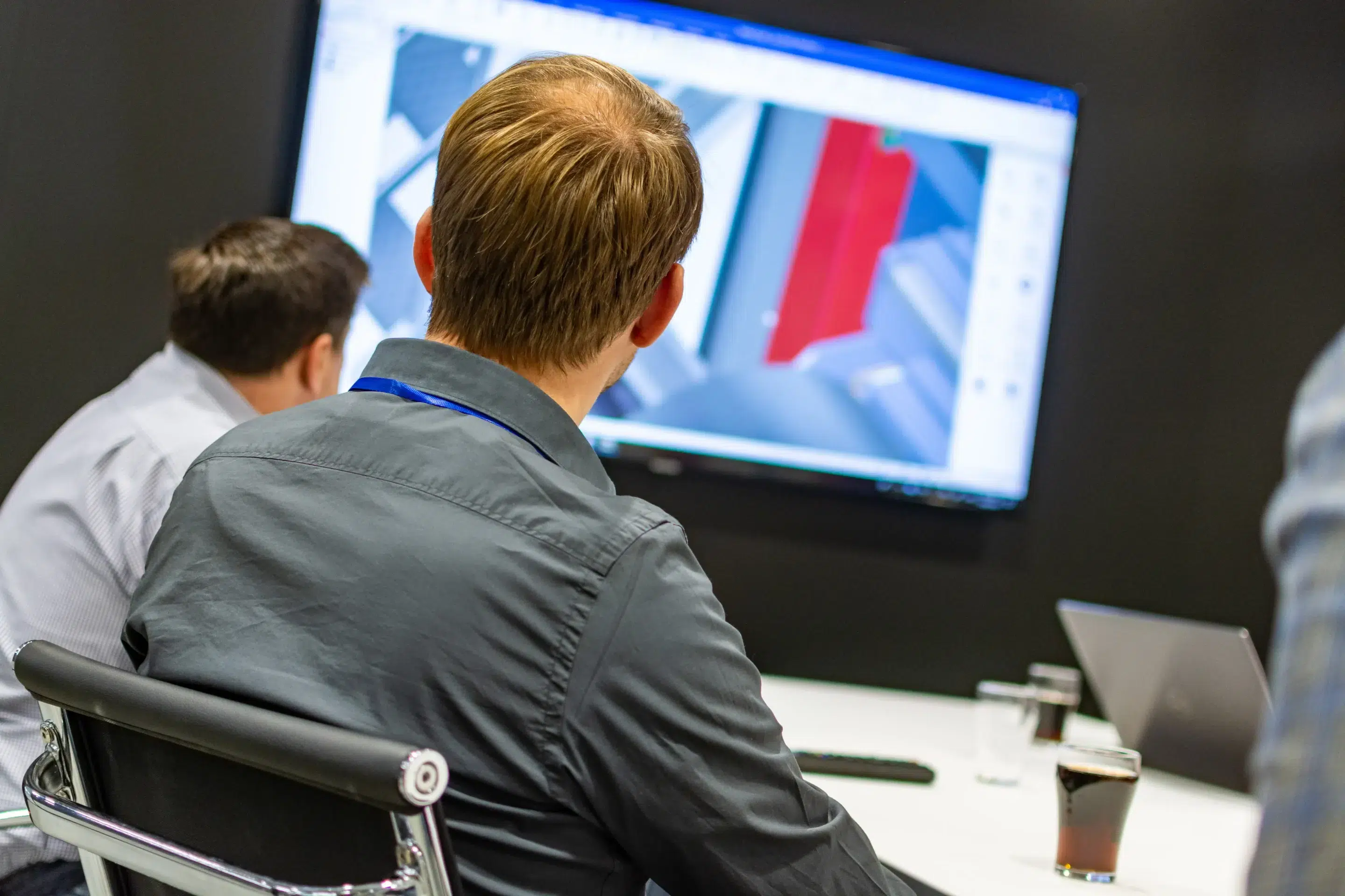 People in a meeting look at a screen with an IronCAD design