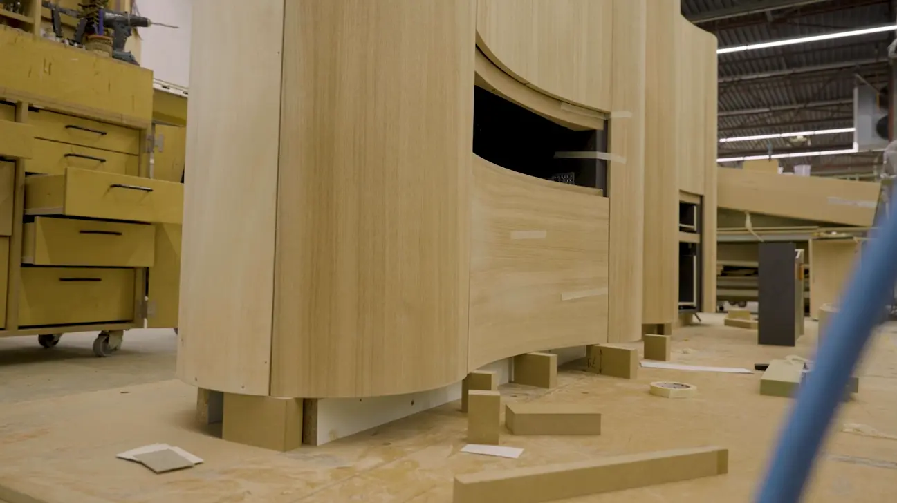 Een houten meubel met ronde vormen in aanbouw in de werkplaats van Technoplanning, als voorbeeld van maatwerkinterieurbouw.