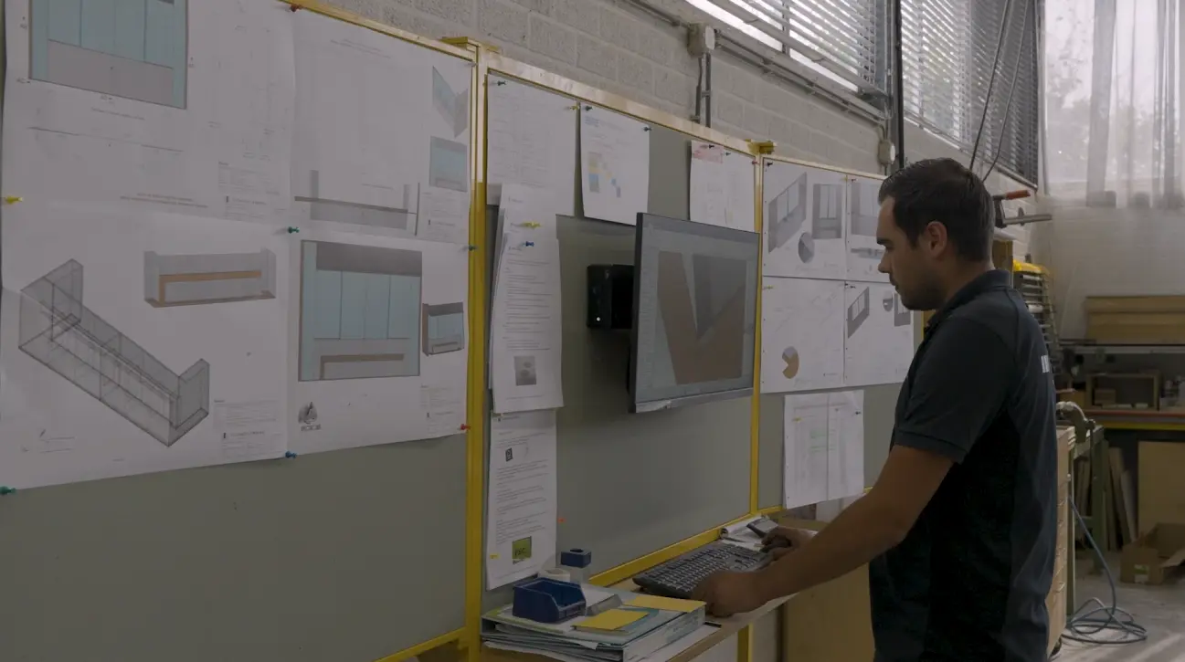Medewerker bekijkt 3D-tekeningen en werktekeningen aan een scherm in de werkplaats van Technoplanning.